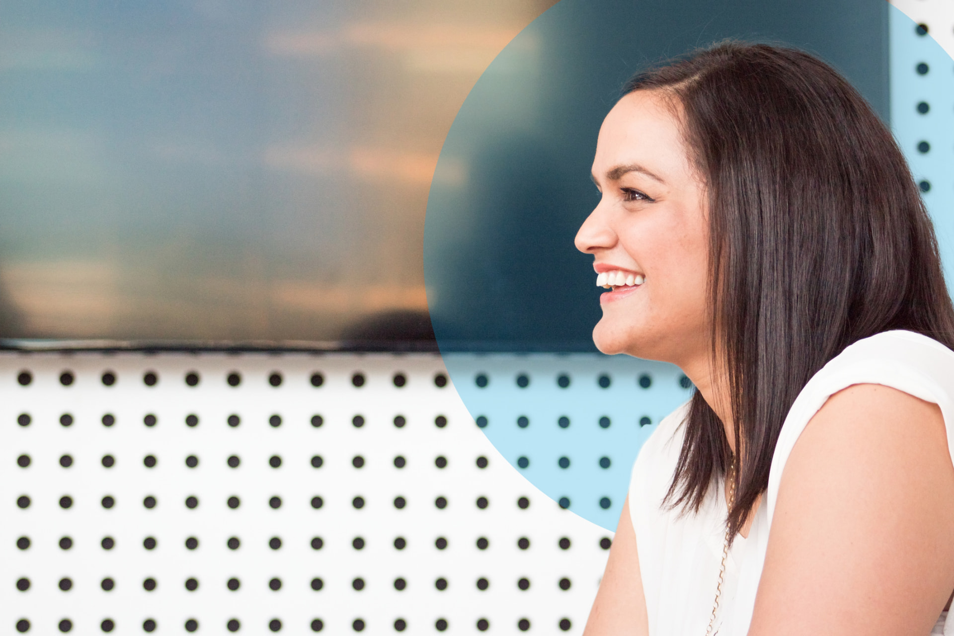 A woman smiling in a bright workplace